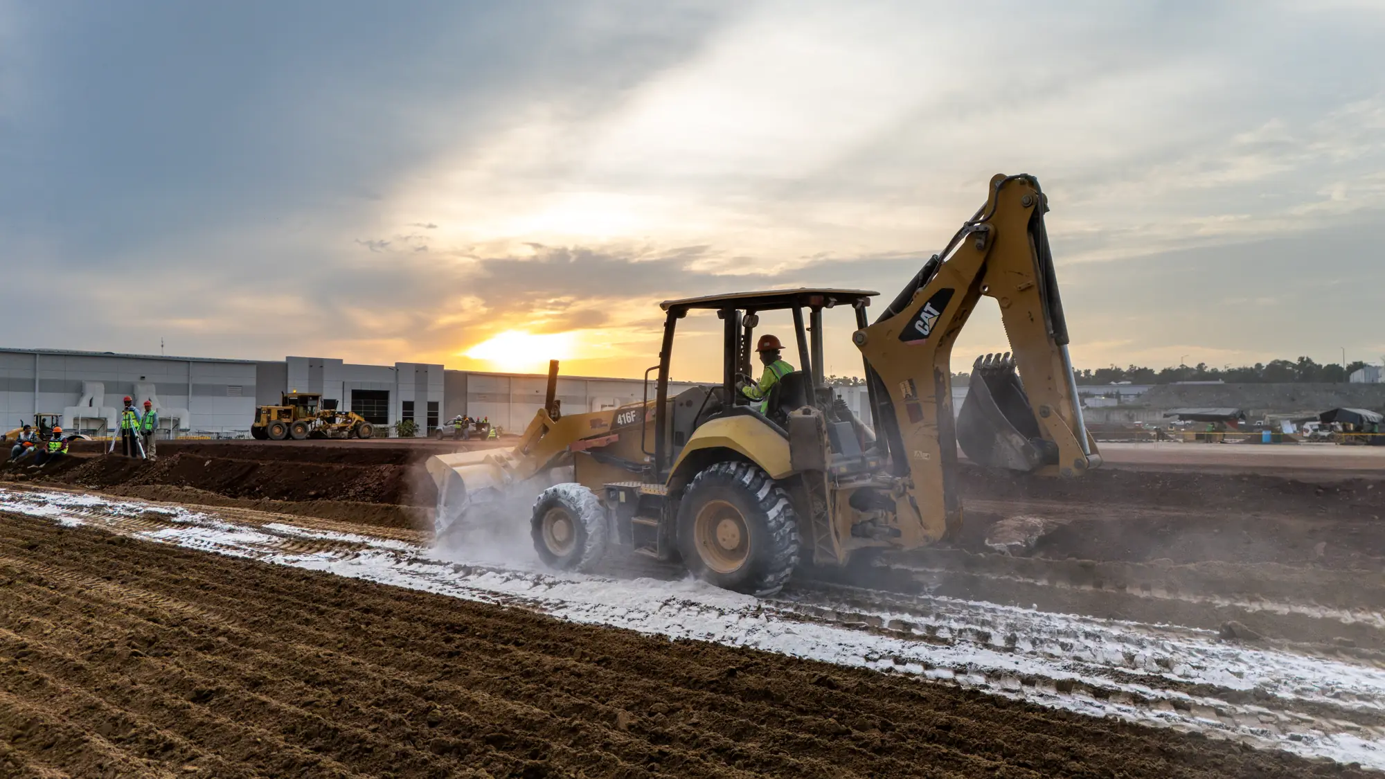 Retroexcavadora trabajando al atardecer en las terracerías de Parque Vesta, El Salto